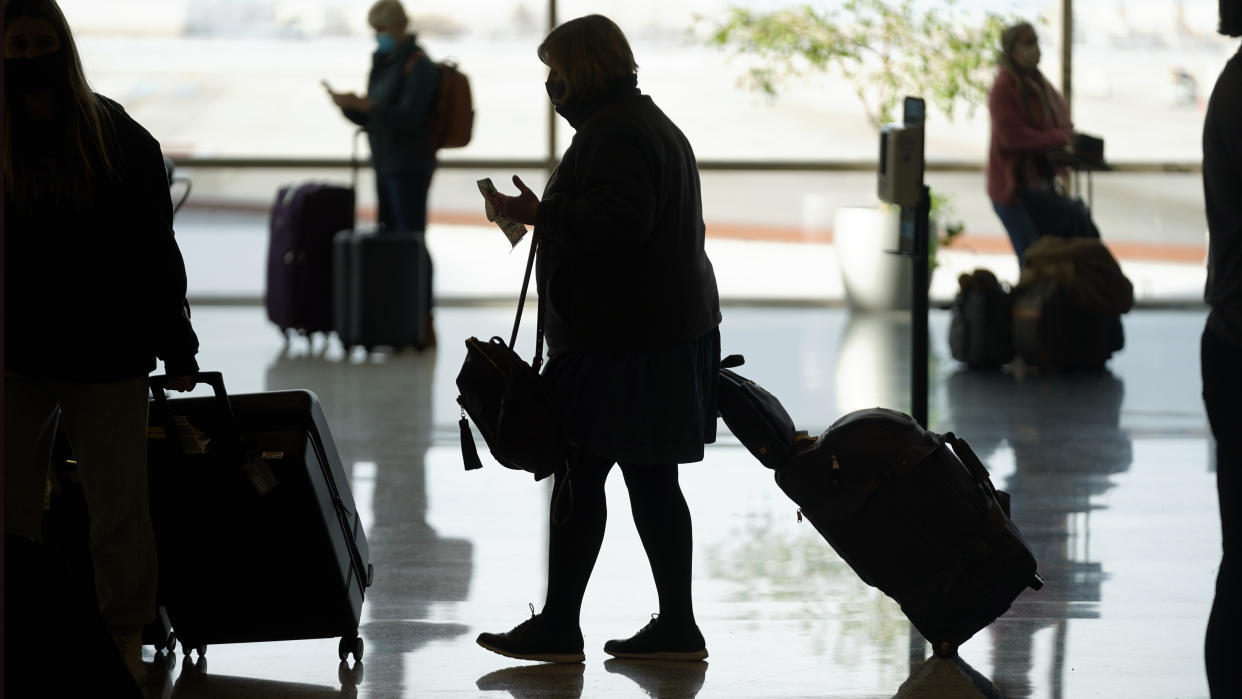 FILE - Travelers pass through Salt Lake City International Airport Thursday, Dec. 30, 2021, in Salt Lake City. Better weather is helping some travelers get home after the New Year's holiday, but airlines are still canceling a high number of flights. By late Tuesday, Jan. 4, 2022, on the East Coast, airlines had scrubbed more than 1,200 flights for the day. That’s a very high number but not compared with Monday’s disruptions. (AP Photo/Rick Bowmer, File)