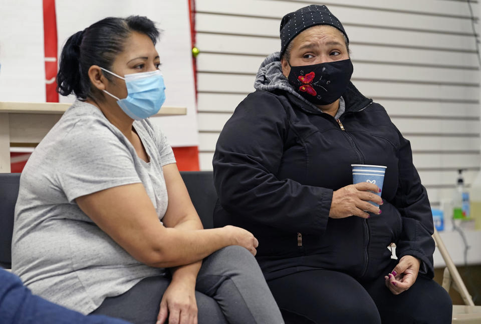 Graciela Uraga, left, a cleaning lady, and Blanca Cedillos, a nanny, react as they watch Joe Biden's presidential inauguration from the Workers Justice Center, an immigrants rights center, Wednesday, Jan. 20, 2021, in the Sunset Park neighborhood of Brooklyn in New York. Cedillos admitted to being "nervous" when the speech started, but after the speech, said she was disappointed Biden didn't mention immigration reform. (AP Photo/Kathy Willens)