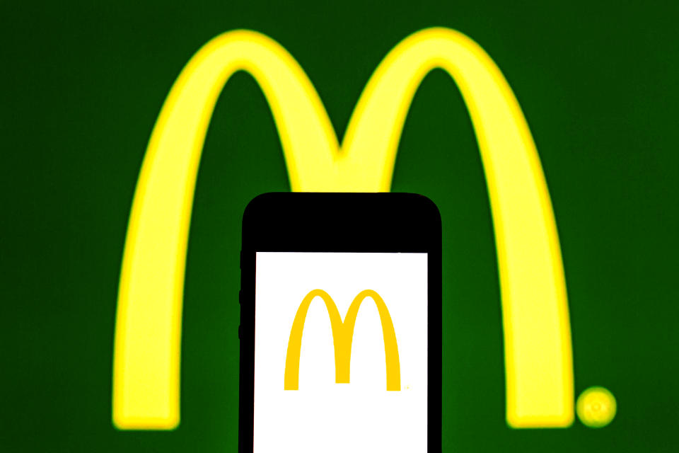 SPAIN - 2021/07/31: In this photo illustration, a McDonald's logo seen displayed on a smartphone and in the background. (Photo Illustration by Thiago Prudencio/SOPA Images/LightRocket via Getty Images)