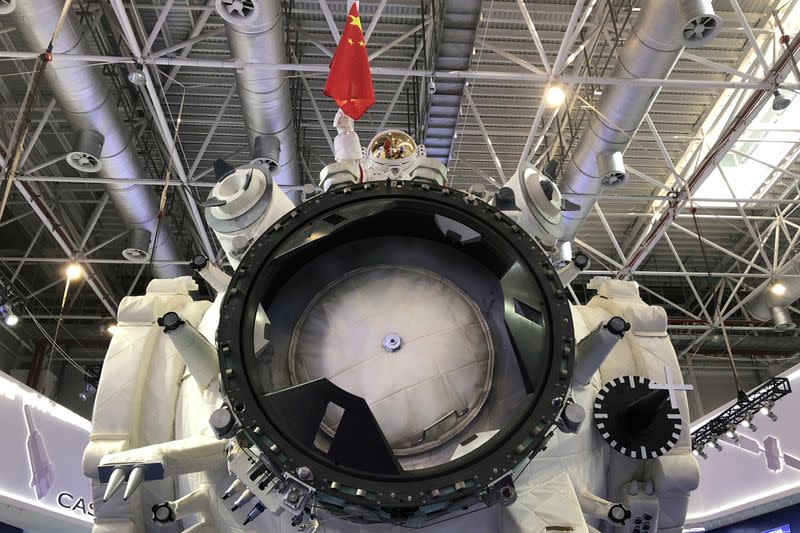 FILE PHOTO: Model of an astronaut holding a Chinese flag is seen above the full-size model of Chinese space station core module Tianhe at the Zhuhai Airshow