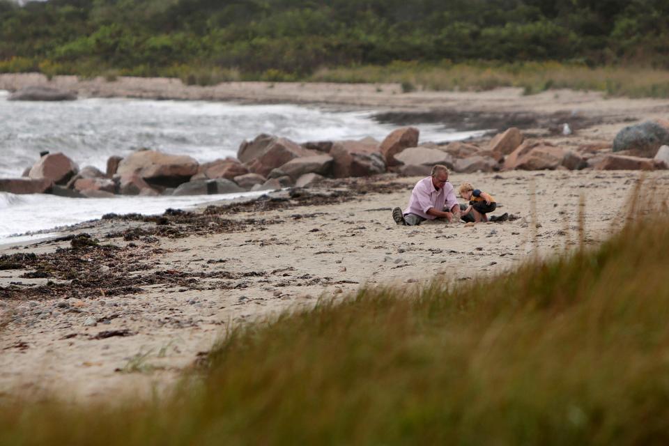 A man and young boy build a sandcastle on Gooseberry Island in Westport.