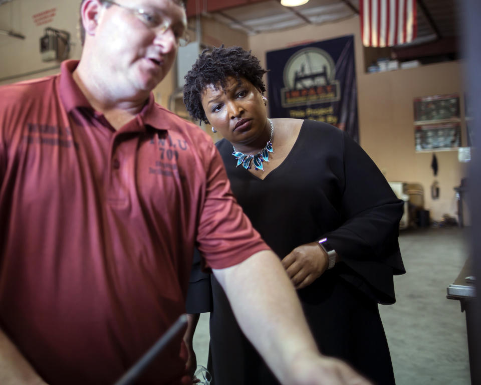 Georgia Democratic gubernatorial candidate Stacey Abrams, right, is given a tour by apprentice coordinator Derrick Sample, left, during a campaign stop at the Ironworkers Local 709 apprenticeship shop to announce her "Jobs for Georgia Plan", Thursday, July 26, 2018, in Pooler, Ga. (AP Photo/Stephen B. Morton)