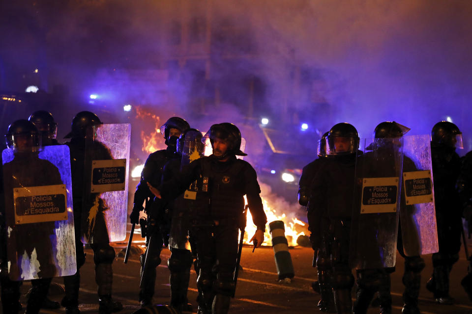 Police in riot gear chases protestors during clashes in Barcelona, Spain, Wednesday, Oct. 16, 2019. Spain's government said Wednesday it would do whatever it takes to stamp out violence in Catalonia, where clashes between regional independence supporters and police have injured more than 200 people in two days. (AP Photo/Emilio Morenatti)