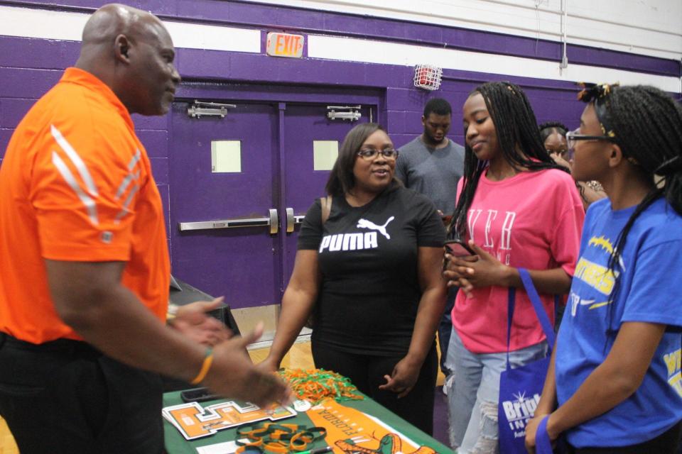 Boderick Johnson, left, president of the Alachua County chapter of the FAMU National Alumni Association, speaks with, from left, mother Kemesha Jones and her two daughters, Jada Lambert and A'Nylia Lambert, during the “2023 North Central Florida College Fair: Where Academics and Athletics Meet” on Saturday at Gainesville High School.
(Credit: Photo by Voleer Thomas, Correspondent)
