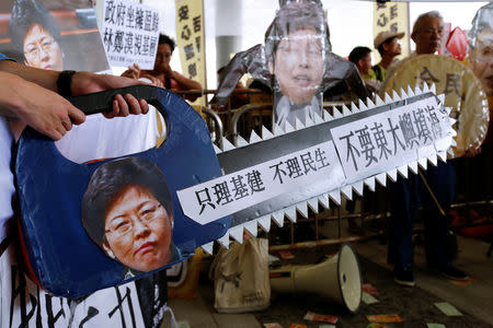 Protesters mock Hong Kong Chief Executive Carrie Lam as they demonstrate against an East Lantau Metropolis project and demand a universal pension scheme outside the Legislative Council in Hong Kong, China October 10, 2018. REUTERS/Bobby Yip