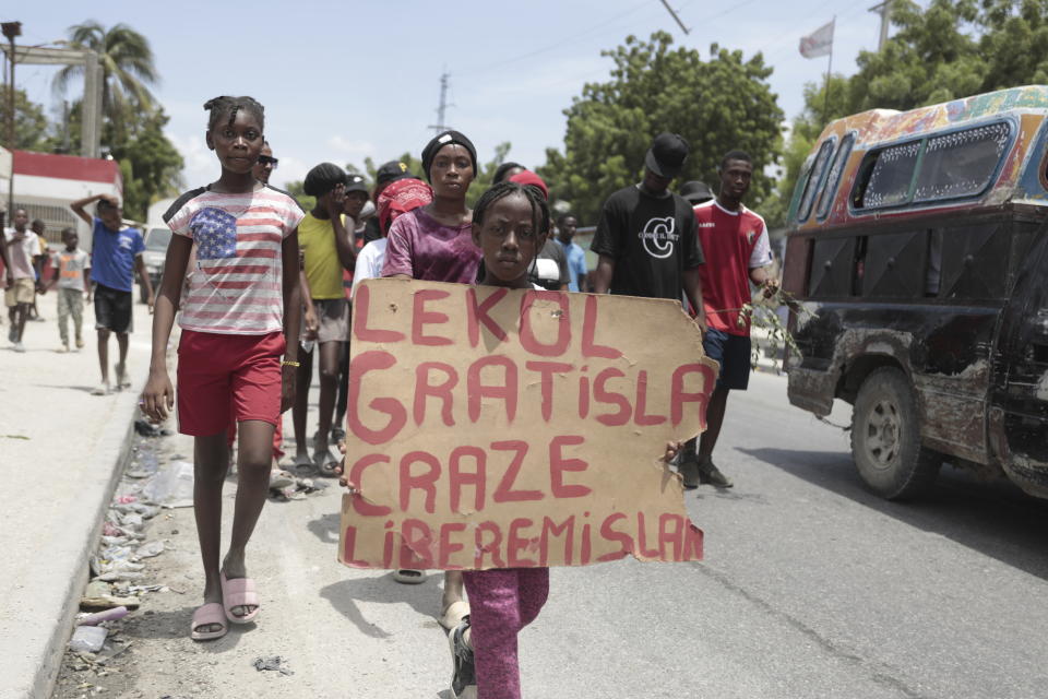 A girl carries a sign that reads in Creole "Free school is broken. Release the nurse," during a march to demand the freedom of New Hampshire nurse Alix Dorsainvil and her daughter, who have been reported kidnapped, in the Cite Soleil neighborhood of Port-au-Prince, Haiti, Monday, July 31, 2023. Dorsainvil works for the El Roi Haiti nonprofit organization and the U.S. State Department issued a "do not travel advisory" ordering nonemergency personnel to leave the Caribbean nation amid growing security concerns. (AP Photo/Odelyn Joseph)