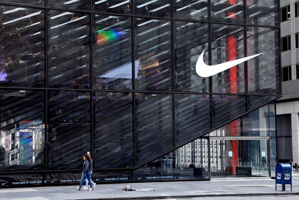 People wearing protective face masks walk past the closed Nike store on a nearly empty 5th Avenue, during the outbreak of the coronavirus disease (COVID-19), in Manhattan, New York city, New York, U.S., May 11, 2020. REUTERS/Mike Segar