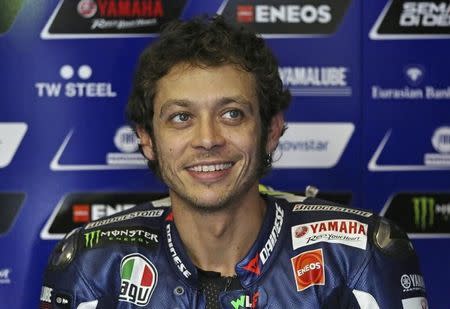 Yamaha MotoGP rider Valentino Rossi of Italy smiles while preparing for the second free practice session of the Malaysian Motorcycle Grand Prix at Sepang International Circuit near Kuala Lumpur October 24, 2014. REUTERS/Olivia Harris