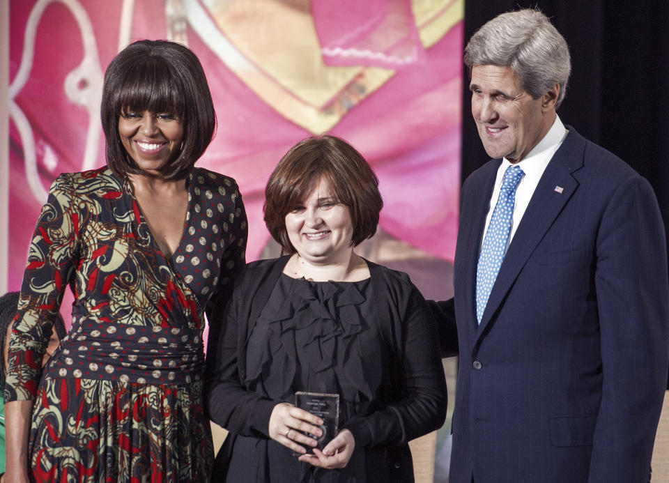 Elena Milashina stands on stage with Michelle Obama John Kerry.