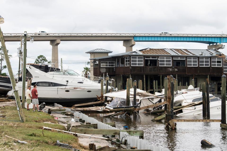 People survey the damage at Oyster Bar Restaurant and Marina in Perdido Key, Fla., on Thursday, Sept. 17, 2020. Hurricane Sally made landfall as a Category 2 early Wednesday morning.