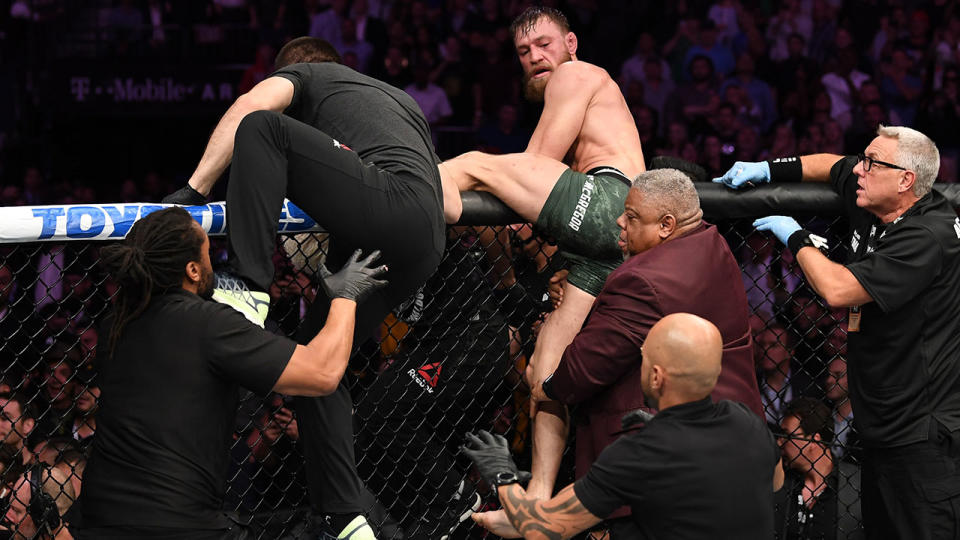Conor McGregor attempts to leave the octagon in chase of Khabib Nurmagomedov. (Photo by Josh Hedges/Zuffa LLC/Zuffa LLC)
