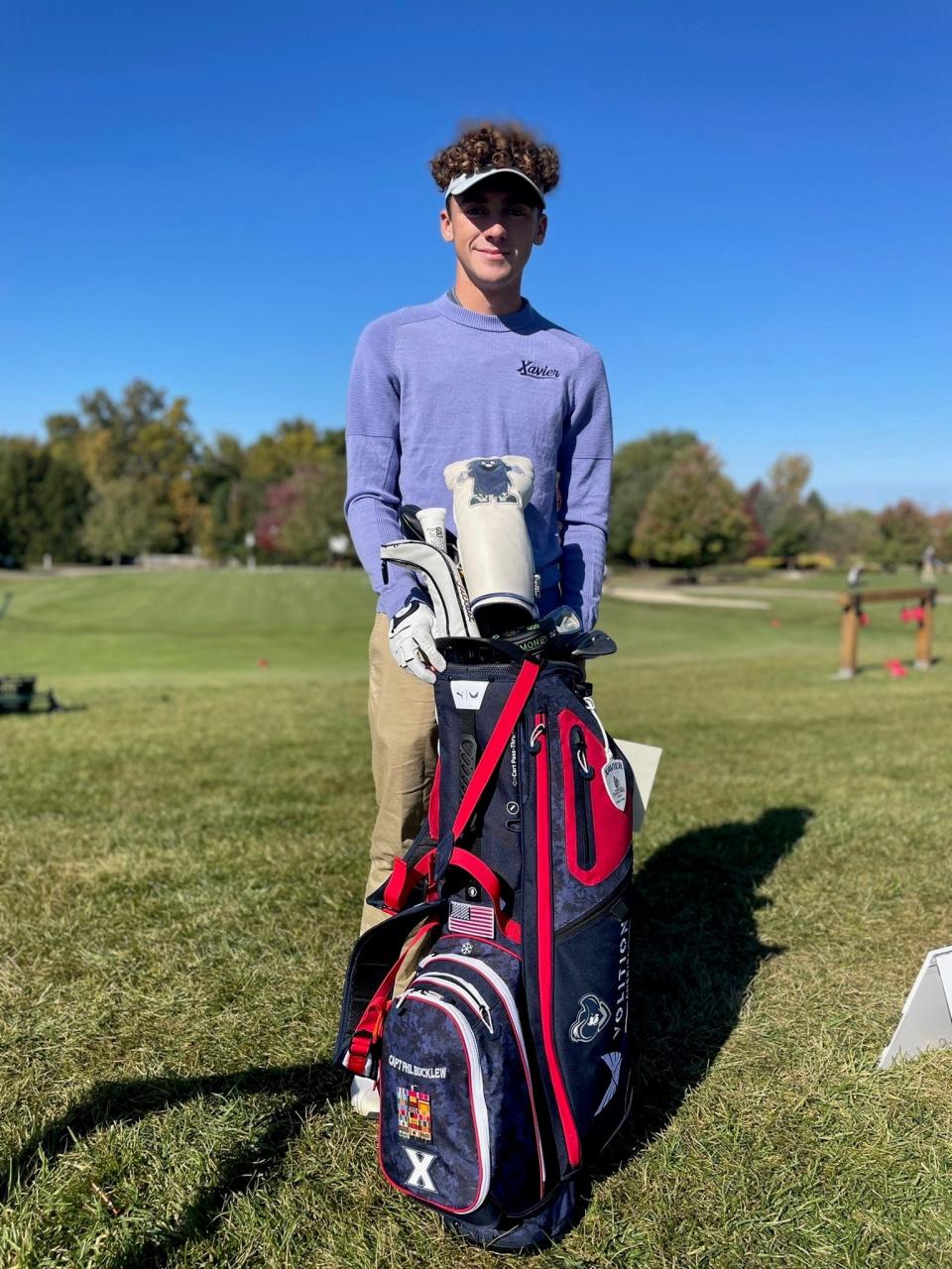 Xavier University men's golfer Mason Witt displays the Phil Bucklew bag. It's a golf bag that's awarded to Xavier's top golfer and commemorates the life and military service of 1936 Xavier grad, Captain Phil Bucklew.