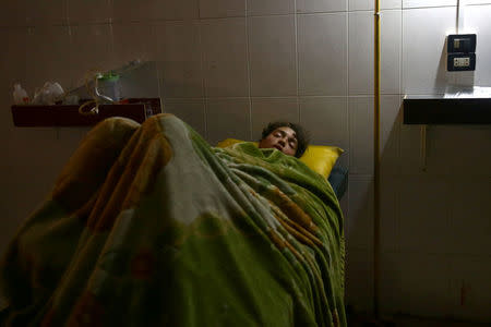 An injured man lies on a bed in the rebel-held, besieged town of Hamouriyeh, Eastern Ghouta, near Damascus, Syria, February 21, 2018. REUTERS/Bassam Khabieh