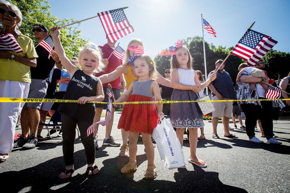 Three young girls wave their American flags during Sparta's Memorial Day Parade in White Deer Plaza Monday, May 27, 2019.