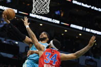 Charlotte Hornets forward Miles Bridges, left, drives to the basket against Oklahoma City Thunder forward Kenrich Williams (34) during the first half of an NBA basketball game in Charlotte, N.C., Sunday, April 7, 2024. (AP Photo/Nell Redmond)