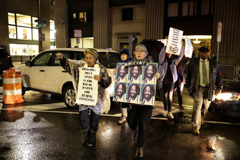 Protestors walk on Broad Street to demonstrate for Mumia Abu-Jamal outside the offices of District Attorney Larry Krasner, Friday, Dec. 28, 2018, in Philadelphia. A judge issued a split ruling Thursday that grants Abu-Jamal another chance to appeal his 1981 conviction in a Philadelphia police officer's death. (AP Photo/Matt Slocum)