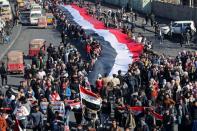 University students carry an Iraqi flag, during ongoing anti-government protests in Baghdad