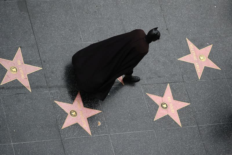 A man dressed as Batman walks on the Hollywood Walk of Fame in Hollywood, Los Angeles