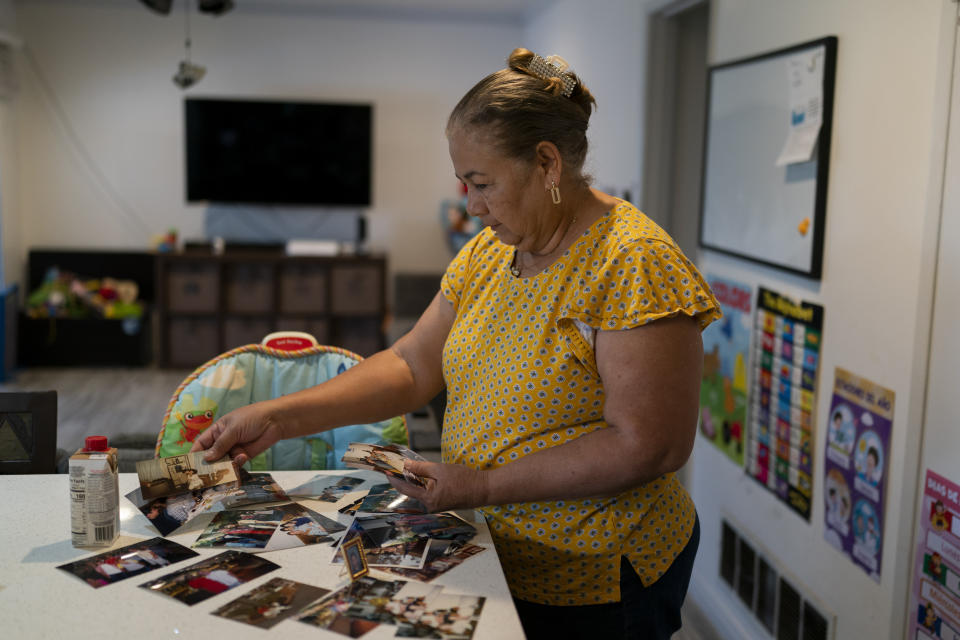 Ana Sandoval, mother of Eyvin Hernandez, a Los Angeles attorney who has been detained for five months in Venezuela, looks at her family photos in Compton, Calif., Monday, Aug. 29, 2022. The Los Angeles attorney detained for five months in Venezuela is pleading for help from the Biden administration, saying in a secretly recorded jailhouse message that he feels forgotten by the U.S. government as he faces criminal charges at the hands of one of the nation's top adversaries. (AP Photo/Jae C. Hong)