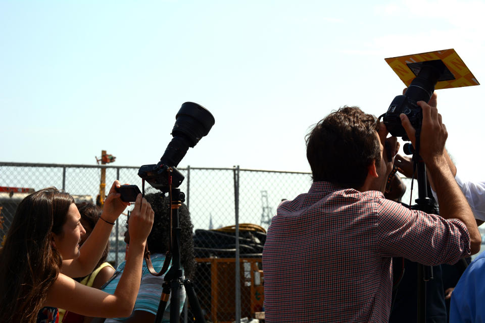 Photographers shooting the eclipse with DSLR cameras and solar filters attached