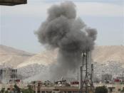 Smoke rises from behind buildings in Jobar, Damascus September 18, 2013. Picture taken September 18, 2013. REUTERS/Msallam Abd Albaset