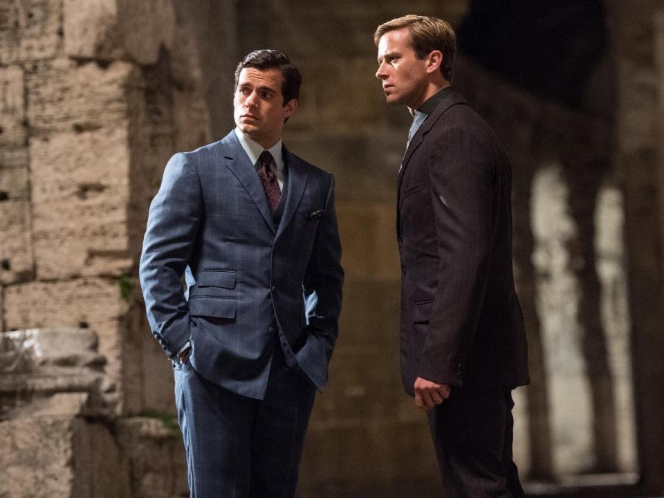 Agent Solo, in a blue suit, and KGB operative Illya, in a dark suit, stand next to each other in this still from "The Man from U.N.C.L.E."