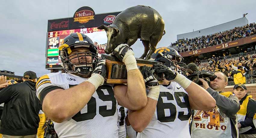 Oct 6, 2018; Minneapolis, MN, USA; Iowa Hawkeyes offensive lineman Ross Reynolds (59) and offensive lineman Keegan Render (69) lift up the Floyd of Rosedale trophy at TCF Bank Stadium.