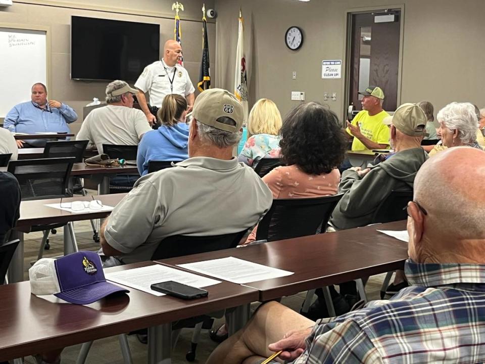 Belleville Police Chief Matt Eiskant, standing, listens to Dave Baumann, in yellow T-shirt, at a town-hall-style meeting of Ward 1 residents at police department headquarters on Wednesday night.