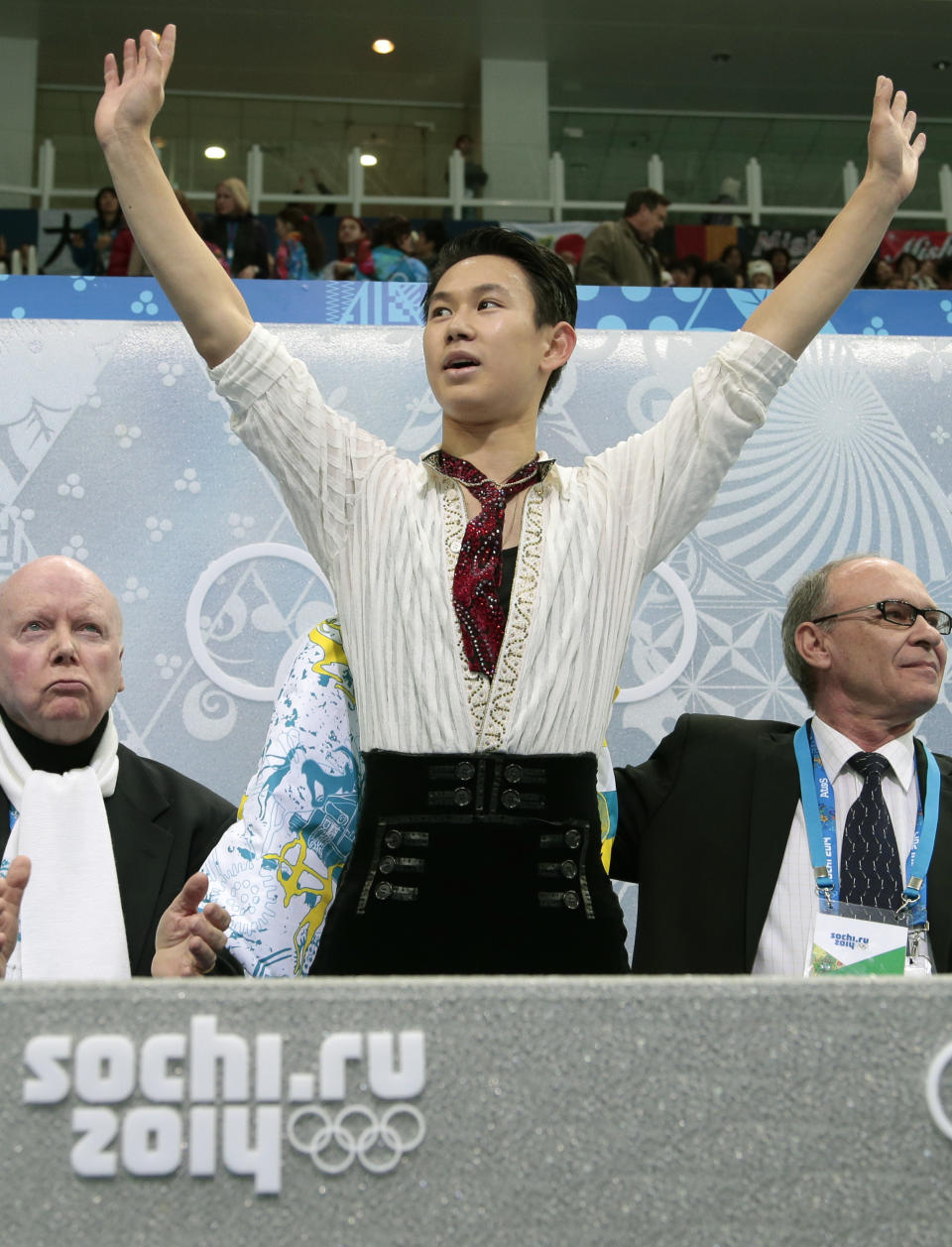 Denis Ten of Kazakhstan, centre, waves to spectators from the results area after the men's free skate figure skating final at the Iceberg Skating Palace at the 2014 Winter Olympics, Friday, Feb. 14, 2014, in Sochi, Russia. (AP Photo/Ivan Sekretarev)