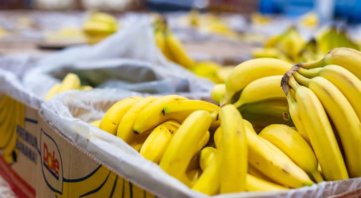 Bunches of Dole (DOLE) bananas in a cardboard box.