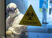 A medical worker wearing protective gear enters the treatment hall of a temporary hospital for coronavirus patients in the Krylatskoye Ice Palace in Moscow, Russia, Wednesday, Nov. 18, 2020. Russia’s health care system has been under severe strain in recent weeks, as a resurgence of the coronavirus pandemic has swept the country. (AP Photo/Pavel Golovkin)