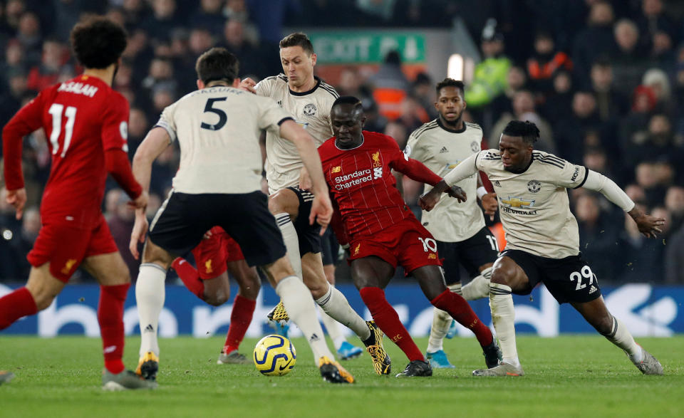 Liverpool's Sadio Mane battles for the ball with Manchester United players.