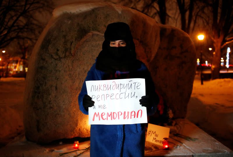 Supporters of the human rights group International Memorial gather at the Solovetsky Stone memorial in Saint Petersburg