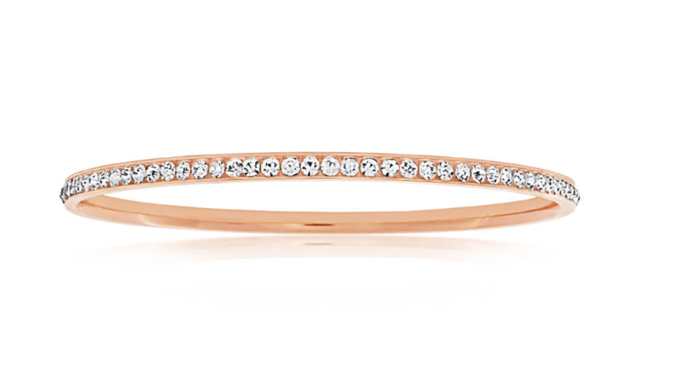 A Stainless Steel Rose Gold Plated Crystal Bangle is studded with crystals.