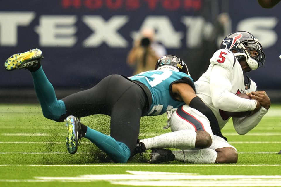 Houston Texans quarterback Tyrod Taylor (5) is sacked by Jacksonville Jaguars cornerback CJ Henderson (23) during the first half of an NFL football game Sunday, Sept. 12, 2021, in Houston. (AP Photo/Sam Craft)