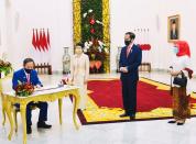 Japan's PM Suga signs guest book at Indonesian Presidential Palace in Bogor
