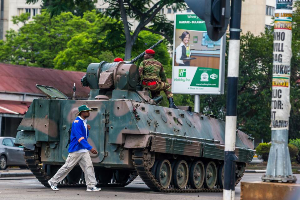 A man walks past&nbsp;an armored personnel carrier stationed at an intersection in Harare as Zimbabwean soldiers regulate traffic on Nov. 15, 2017. (Photo: - via Getty Images)