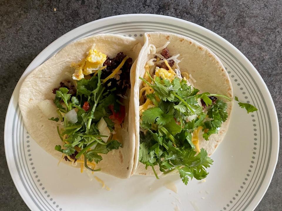 plate of breakfast tacos with cilantro and other toppings