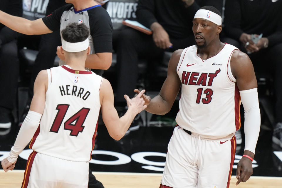 Miami Heat guard Tyler Herro (14) congratulates center Bam Adebayo (13) after a play during the first half of Game 3 of an NBA basketball first-round playoff series against the Boston Celtics, Saturday, April 27, 2024, in Miami. (AP Photo/Wilfredo Lee)