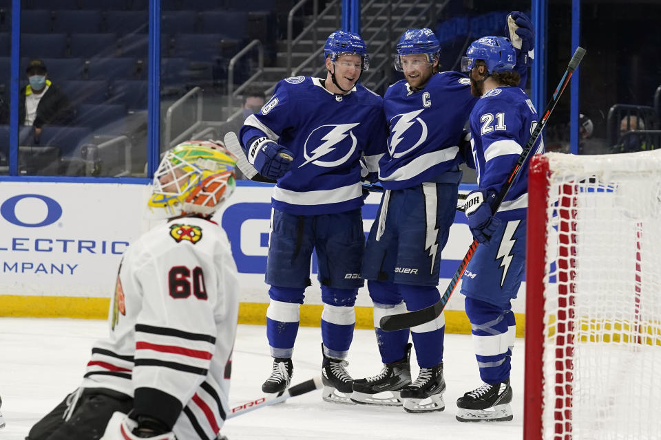 Tampa Bay Lightning left wing Ondrej Palat (18) celebrates with teammates center Steven Stamkos (91) and center Brayden Point (21) after scoring against Chicago Blackhawks goaltender Collin Delia (60) during the second period of an NHL hockey game Friday, Jan. 15, 2021, in Tampa, Fla. (AP Photo/Chris O'Meara)