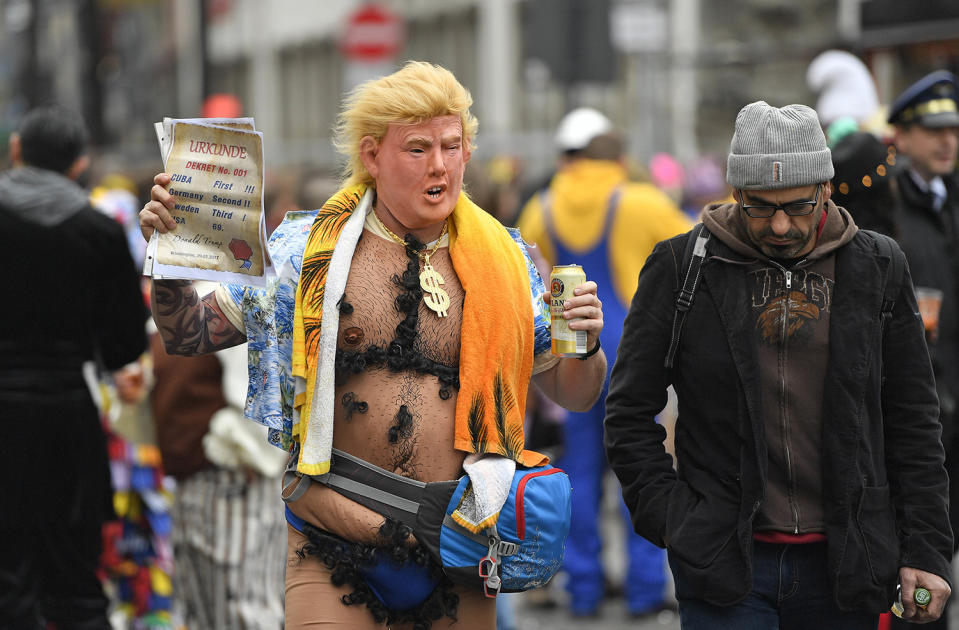 <p>A man with a Donald Trump mask holds a paper reading ‘ Cuba first, Germany second, Sweden third, USA 69.’ when tens of thousands revelers dressed in carnival costumes celebrate the start of the street-carnival in Cologne, Germany, Feb. 23, 2017. (Photo: Martin Meissner/AP) </p>