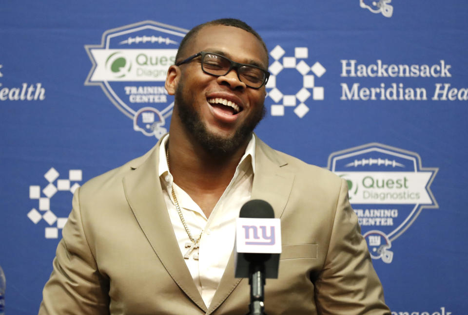 FILE - New York Giants NFL football draft pick Evan Neal reacts during a press conference in East Rutherford, N.J. on Saturday, April 30, 2022. (AP Photo/Noah K. Murray, File)