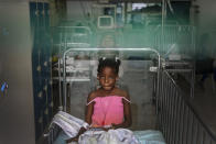 A girl rests on a bed as she listens to music at the Saint Damien Pediatric Hospital of Port-au-Prince, Haiti, Sunday, Oct. 24, 2021. Haiti's capital has been brought to the brink of exhaustion by fuel shortages and the capital's main pediatrics hospital says it has only three days of fuel left to run ventilators and medical equipment. (AP Photo/Matias Delacroix)