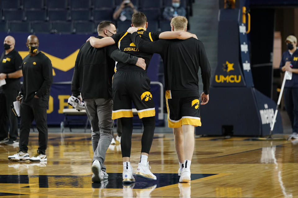 Iowa forward Jack Nunge is helped off the court during the first half of an NCAA college basketball game against Michigan, Thursday, Feb. 25, 2021, in Ann Arbor, Mich. (AP Photo/Carlos Osorio)