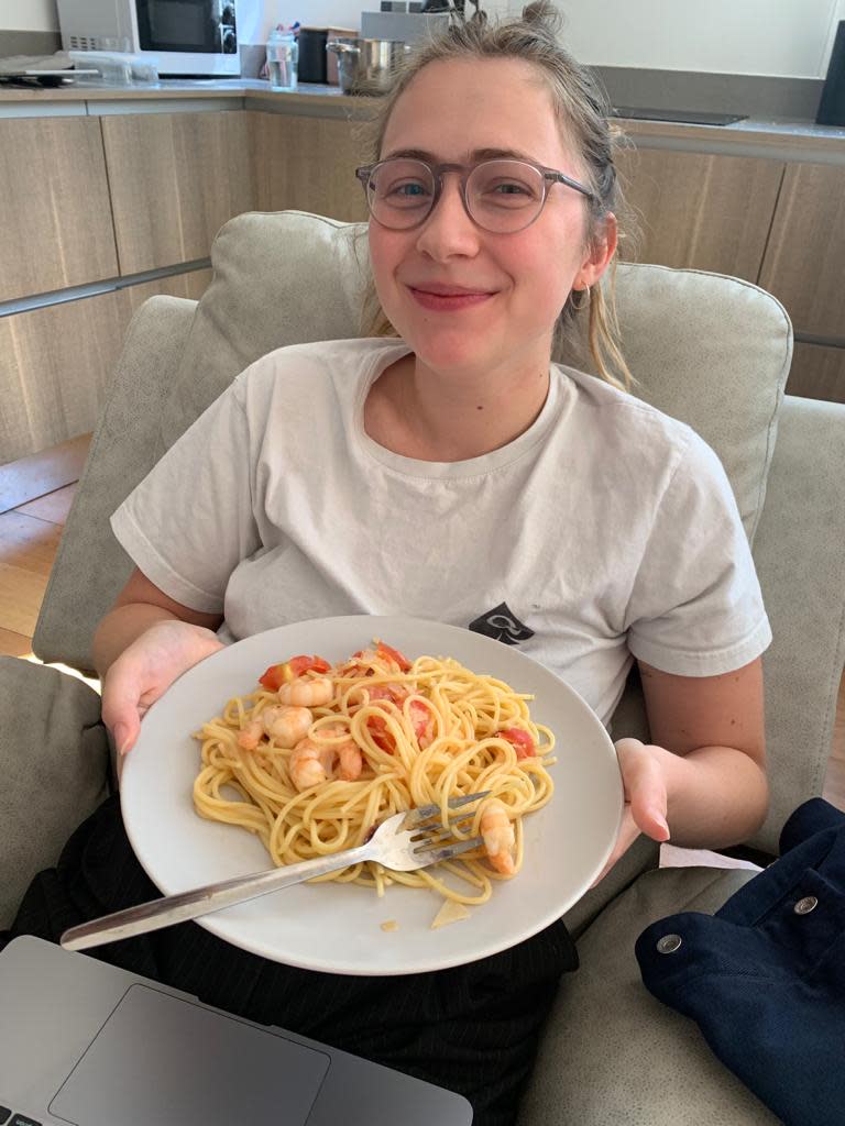 Writer Kim Schewitz holding a plate of pasta.