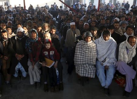 Afghan men sit as they wait to apply for passports at a passport department office in Kabul, Afghanistan, November 29, 2015. REUTERS/Omar Sobhani