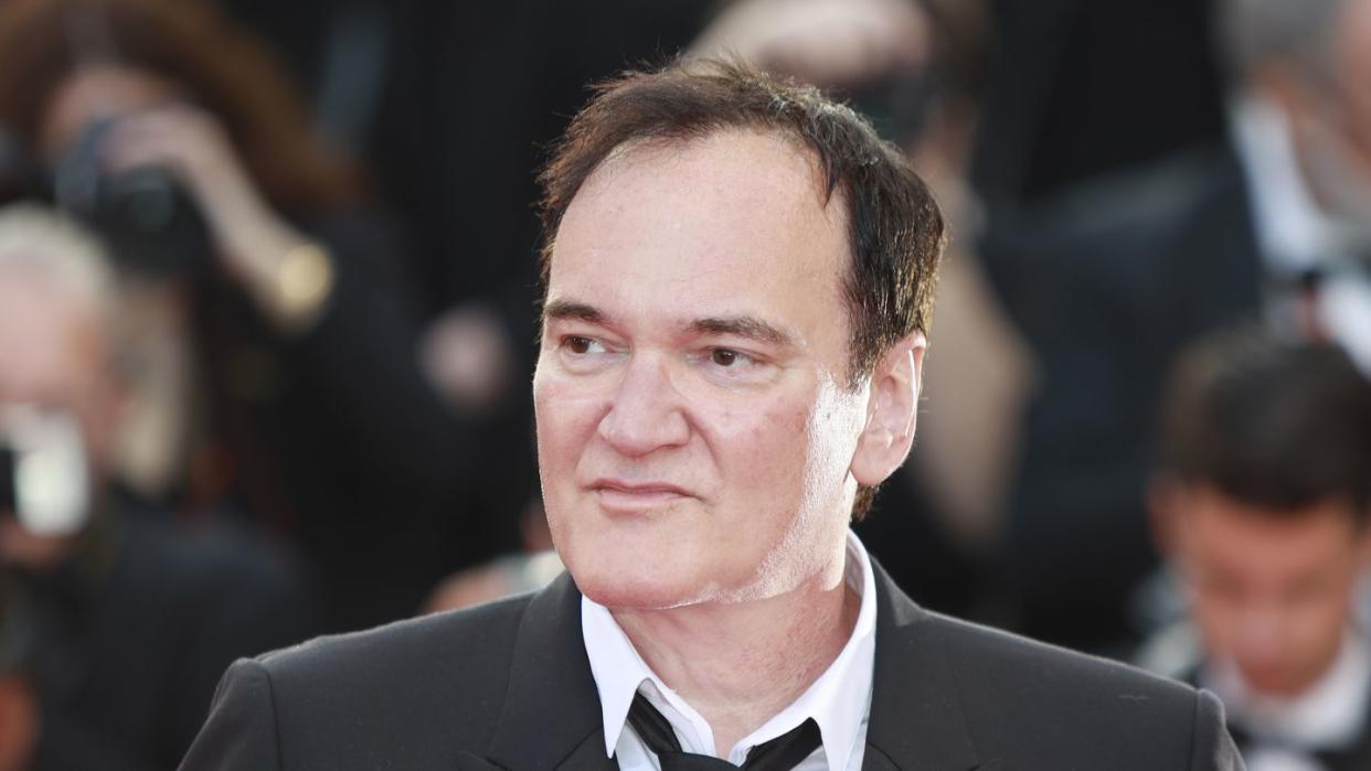 quentin tarantino in a suit and tie and looking to his right