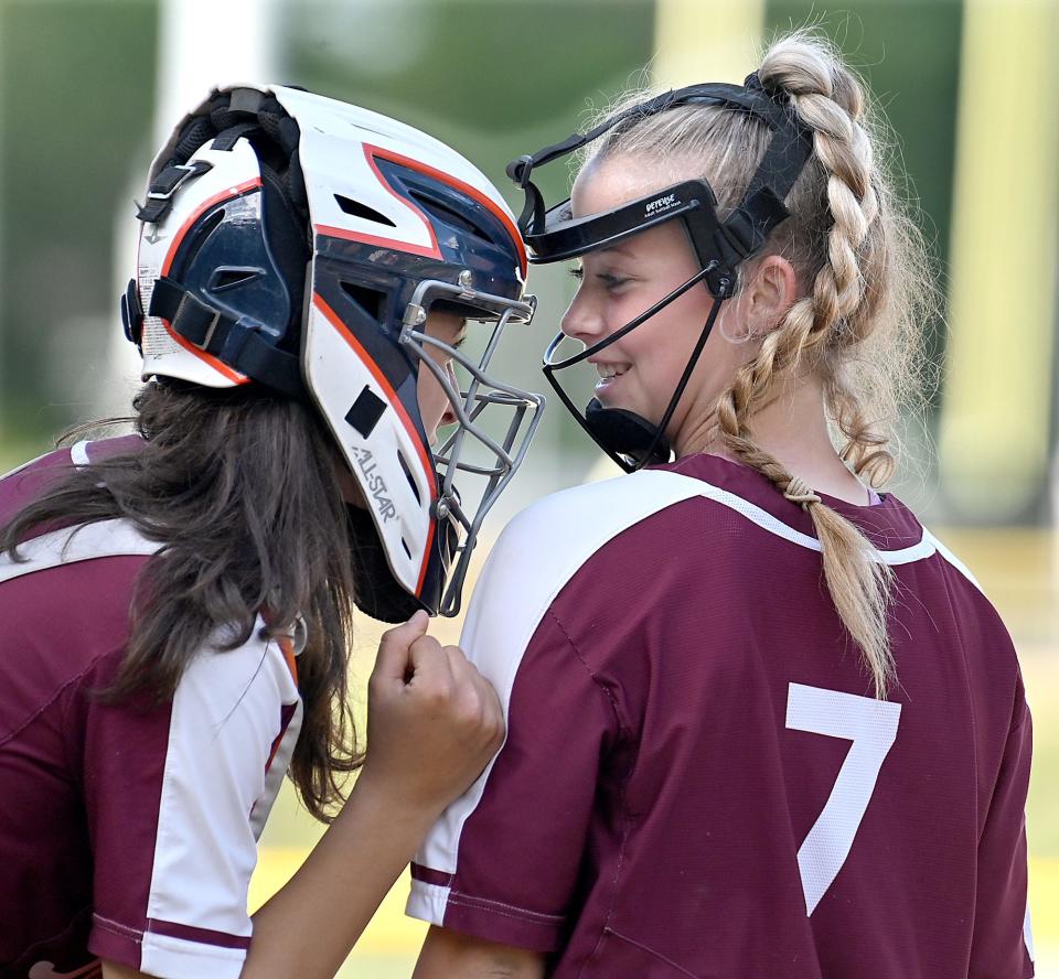 Millis catcher Frankie Pizzarella (left) gives her pitcher, Riley Caulfield, (7) some encouragement as Caulfield takes the  mound in the late innings against Hopkinton at Hopkinton High School, May 27, 2021.