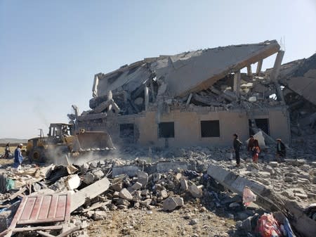 People search among the rubble at the site of Saudi-led air strikes on a Houthi detention centre in Dhamar