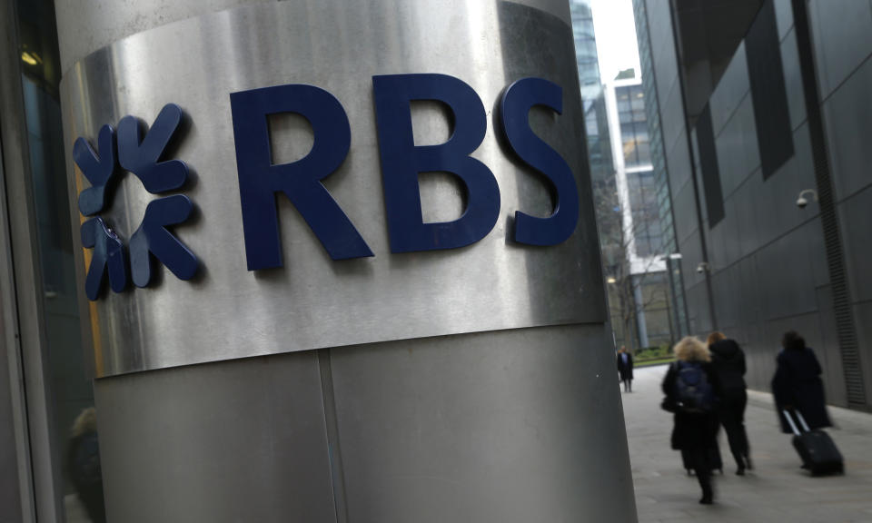 FILE - In this Thursday, Jan. 26, 2017 file photo, people walk past one of the headquarter buildings showing the logo of the Royal Bank of Scotland in London. The British government has sold a 7.7 percent stake in Royal Bank of Scotland, taking a tentative step toward returning the bank to private ownership almost a decade after it was bailed out at the height of the financial crisis. (AP Photo/Alastair Grant/File)